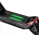 Close-up view of an Evolvate Pro Panther ES800 Super Electric Scooter's battery compartment, revealing a green glowing battery pack. The sleek black frame, accented with red at the rear, features dual motors for enhanced performance. Off-road tires complement the scooter's robust design. The battery compartment is open for visibility.