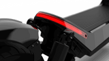 A close-up image of the Evolvate Pro Panther ES800 Super Electric Scooter's rear end, showcasing a sleek, black design with a prominent red LED strip light. The image highlights the scooter's modern and streamlined aesthetic, with detailed focus on the back wheel equipped with off-road tires and suspension.